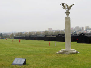 Majdanek: Drei-Adler-Säule vor Häftlingsbaracken, im Hintergrund die heutige Stadt