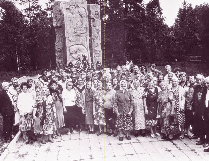 Dieses Foto zeigt etwa 60 ältere Menschen vor einem Gedenkstein, der an das Todeslager Osaritschi erinnert. Die Erinnerung an das Todeslager Osaritschi ist unter anderem mit diesem Foto nun Teil der Wanderausstellung "Vernichtungsort Malyj Trostenez. Geschichte und Erinnerung". Das Denkmal wurde erst 194 errichtet. Das Foto entstand bei einem Treffen ehemaliger Häftlinge am 3. Juli 1997. Foto: Museum des Großen Vaterländischen Krieges Minsk