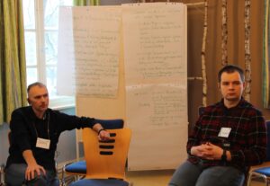 Unser Foto zeigt zwei der polnischen Teilnehmenden, die vor einer Pinnwand sitzen, auf der in grüner Handschrift Ideen festgehalten wurden im Projekt "Erinnern-inklusiv". 